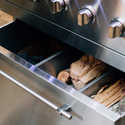 Integrated fuel drawer in the optional stainless cart keeps charcoal and wood neatly stored and within reach.