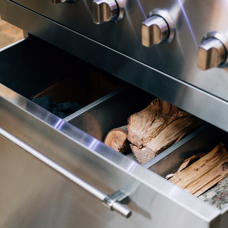 Integrated fuel drawer in the optional stainless cart keeps charcoal and wood neatly stored and within reach.