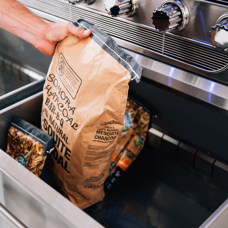 Integrated fuel drawer in the optional stainless cart keeps charcoal and wood neatly stored and within reach. 