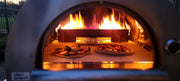 Close-up front view of inside the KoKoMo Dual-Fuel Pizza Oven while two pizzas cook with flames visible