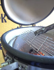 Setting the stainless steel cooking grate into place on the KoKoMo 21‑inch kamado grill