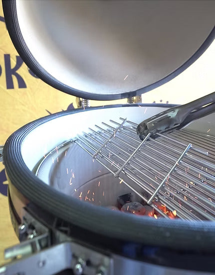 Setting the stainless steel cooking grate into place on the KoKoMo 21‑inch kamado grill