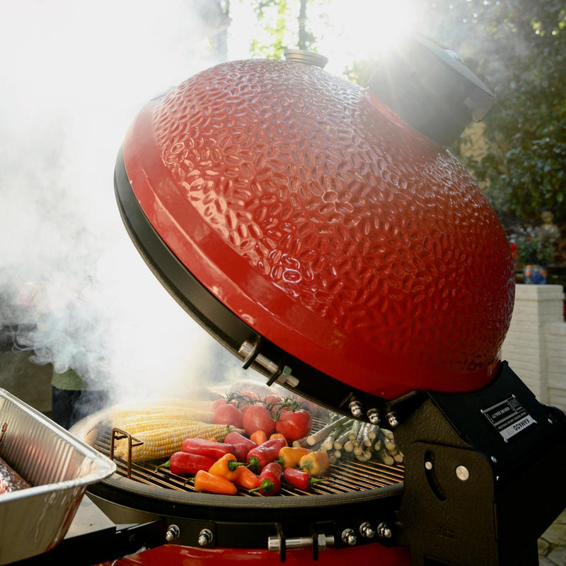 Kamado Joe Big Joe II 24-inch ceramic grill with lid open and colorful vegetables grilling over charcoal shows the large cooking area and smoky searing performance for backyard feasts